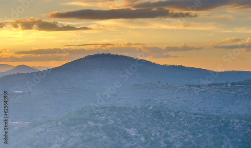 Mountains landscape on sunset. Mountain view from Mola De Segart mountain in Sierra Calderona national park in Valencia, Spain. Sunset over mountains. Landscape of a mountain valley. Hill on sunrise. © MaxSafaniuk
