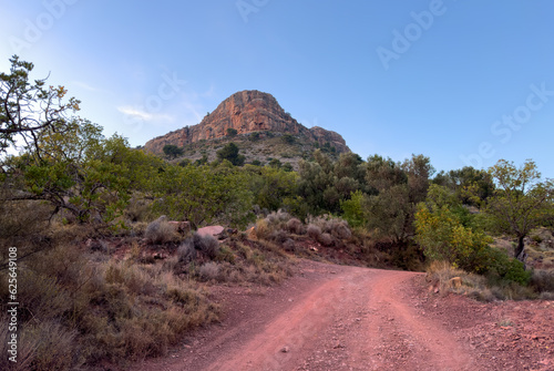 Road in mountains on sunset. View  on Mola De Segart mountain in Sierra Calderona national park in Valencia, Spain. Sunset over rock mountains. Landscape of a mountain valley. Hill on sunrise. photo