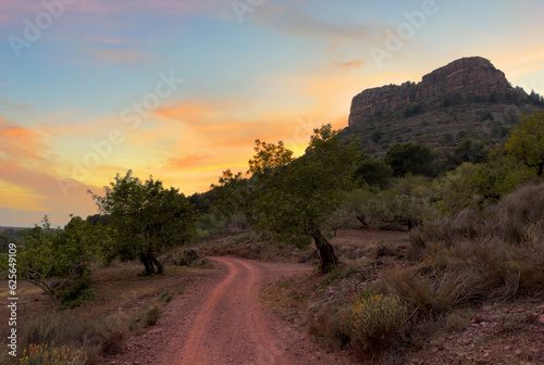 Road in mountains on sunset. View on Mola De Segart mountain in Sierra Calderona national park in Valencia, Spain. Sunset over rock mountains. Landscape of a mountain valley. Hill on sunrise.
