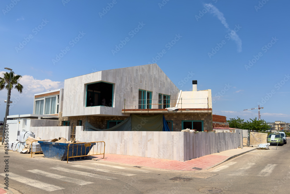 Naklejka premium Prefabricated home under construction. Construction of Modular house. Villa under construction. Prefab residential home building on Construction site near beach of Mediterranean sea. Home renovation.