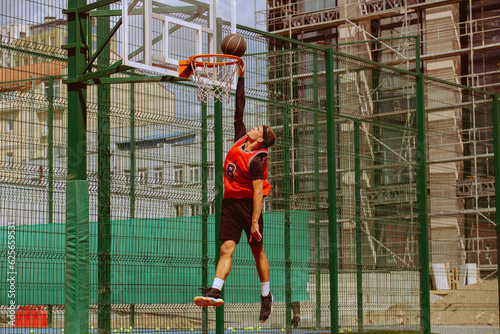 A basketball player plays streetball on a hot day.