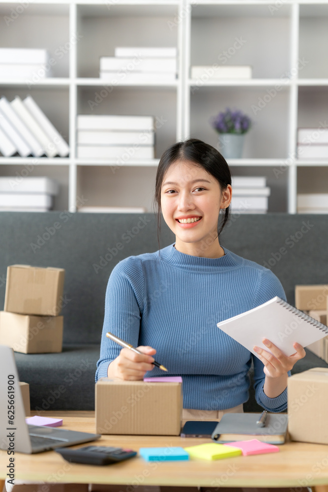 Young business owner woman prepare parcel box and standing check online orders for deliver to customer on tablet, laptop Shopping Online concept. Young business owner woman prepare parcel box and standing check online orders for deliver to customer on tablet, laptop Shopping Online concept.