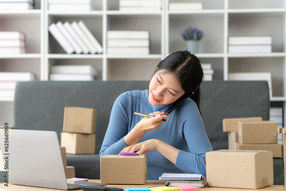 Young business owner woman prepare parcel box and standing check online orders for deliver to customer on tablet, laptop Shopping Online concept. Young business owner woman prepare parcel box and standing check online orders for deliver to customer on tablet, laptop Shopping Online concept.