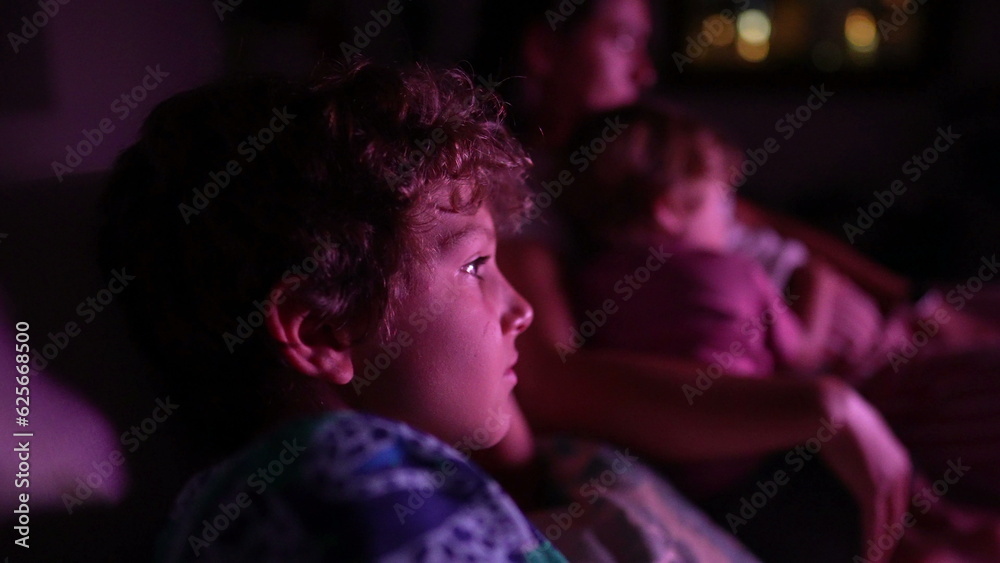 Child watching television screen at night Child watching television screen at night