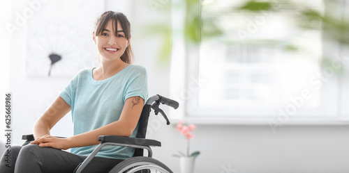 Happy young woman in wheelchair at home