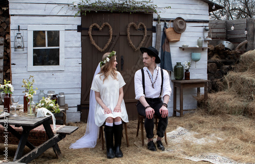 country bride in a white short dress and groom in a white shirt in the village wedding, boho style.