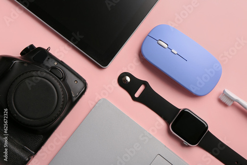 Modern gadgets on pink background, closeup