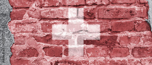 Banner with Swiss Flag on old brick wall. Symbol of Swiss Confederation. White cross on red background. Patriotic street art. Switzerland National Day. Header for website, news, blog. Federation Day photo