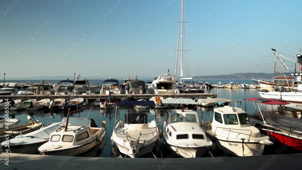 Beautiful yachts on the pier in the port of the Adriatic Sea in the village of Brela Croatia. The resort village of Brela on the Adriatic coast of Croatia Beautiful yachts on the pier in the port of the Adriatic Sea in the village of Brela Croatia. The resort village of Brela on the Adriatic coast of Croatia