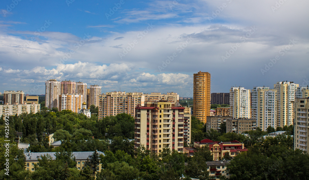 Cityscape - panoramic top view of a residential quarter with modern high-rise buildings with green trees on a sunny summer day and blue sky with white clouds in Reutov, Moscow region and copy space