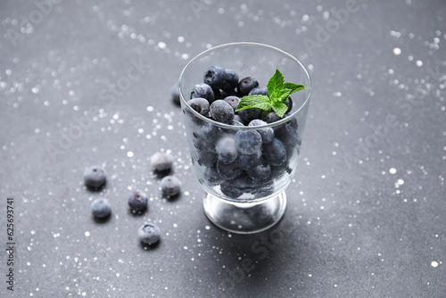 Glass of frozen blueberry with mint leaves on black grunge background