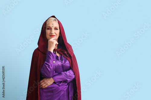 Mature witch on blue backgr...