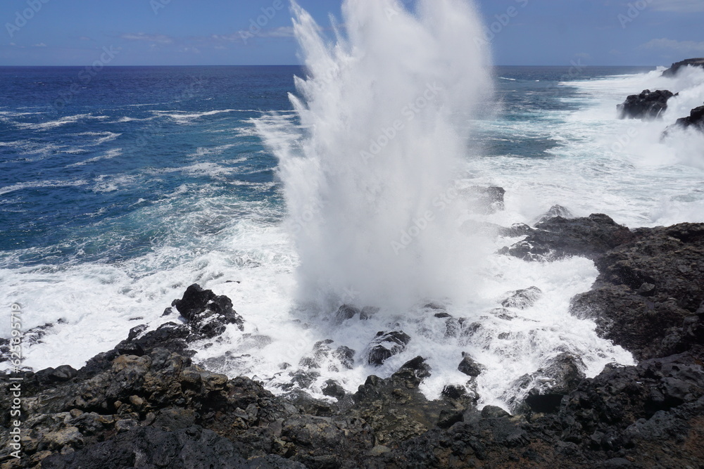 waves crashing on lava rocks on the tropical island of La Réunion, France