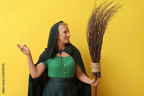 Mature witch with broom on ...
