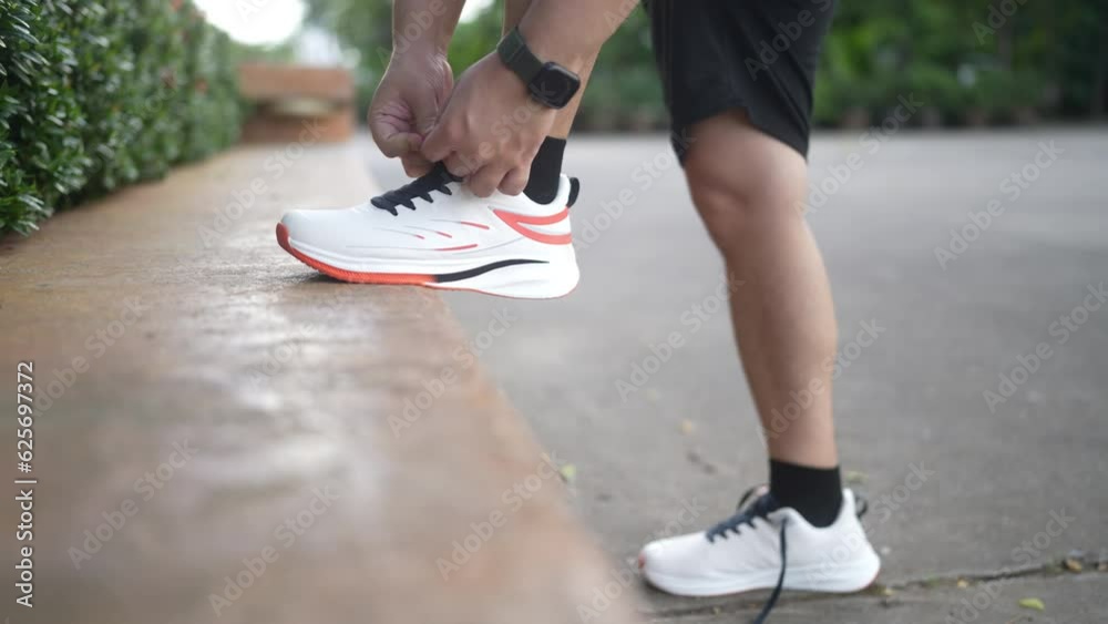Male athlete tying shoelaces at the park. Male athlete tying shoelaces at the park.