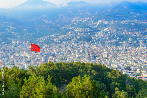 Alanya houses visible behind the Turkish flag. View from top of the Alanya castle in Alanya, Antalya region, Turkey. 