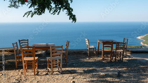 Gokceada  Imbros  coastline and a cute village tea garden view with wooden chairs and table. Tepek  y village      naralt  -Pinarbasi location  Aegean Turkey