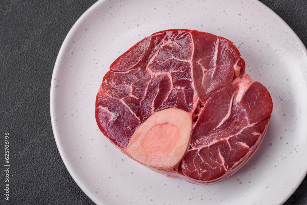 Fresh raw beef steak with bone or ossobuco with salt, spices and herbs Fresh raw beef steak with bone or ossobuco with salt, spices and herbs