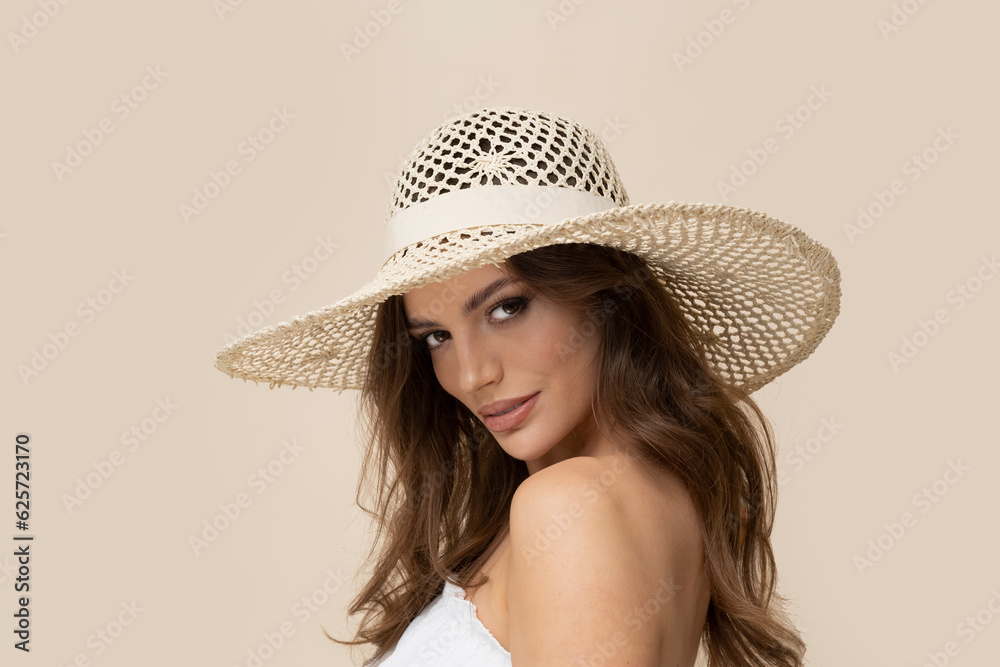 Very attractive brunette in straw hat and white dress on creamy background. Very attractive brunette in straw hat and white dress on creamy background.