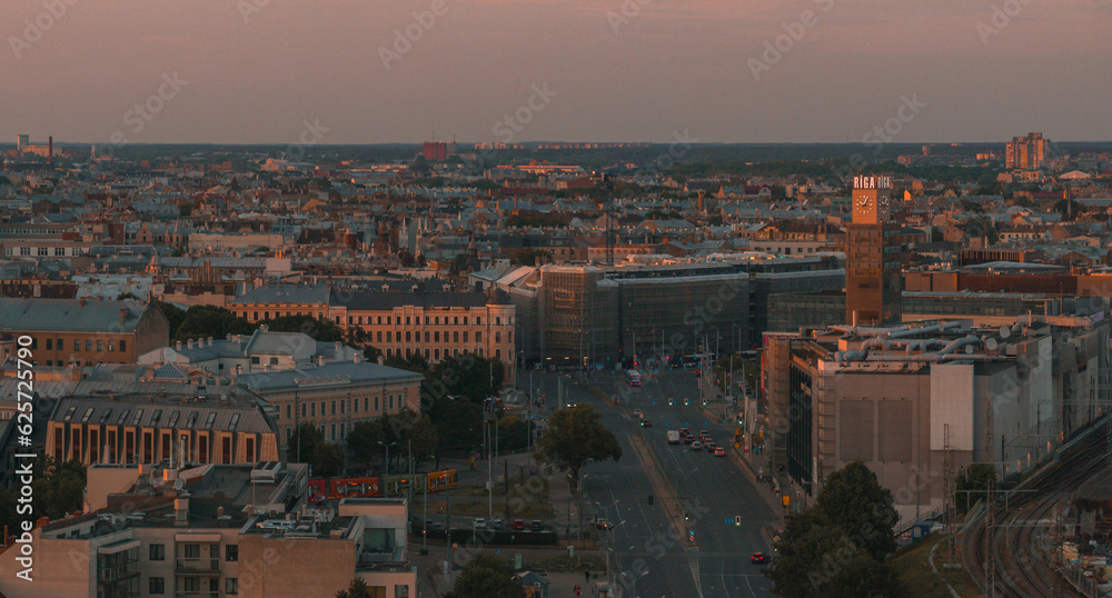 Summer sunset in Riga, Latvia. Aerial view of Riga, the capital of Latvia at sunset. Beautiful buildings, bridges and transport going through the city.