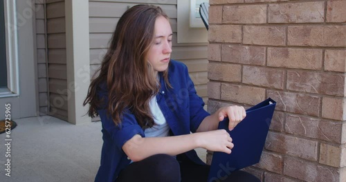 Sad Student Sitting on Steps Outside of a Suburban House