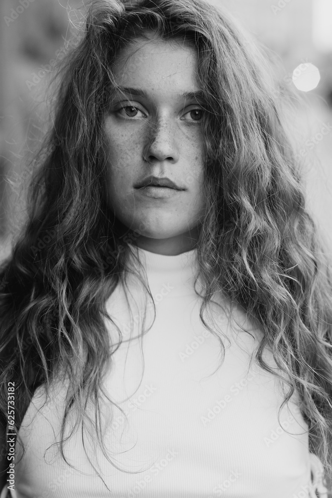 A black-and-white picture of a chic young girl with curly hair