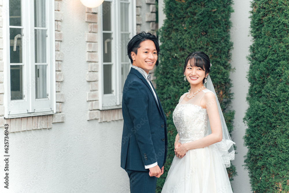 Fototapeta premium 結婚式で結婚式場の庭で前撮りをする新郎新婦(ガーデンウェディング)