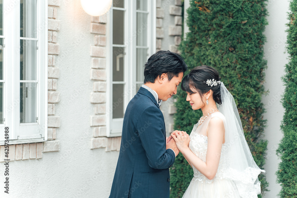 Naklejka premium 結婚式で結婚式場の庭で前撮りをする新郎新婦（ガーデンウェディング） 