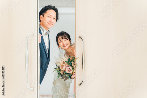 会場のゲスト・友達をドアから覗き見する・扉から顔を出す新郎新婦
 photo