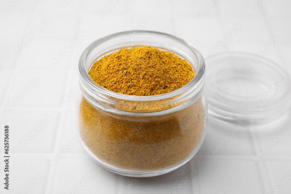 Jar with curry powder on white table, closeup Jar with curry powder on white table, closeup
