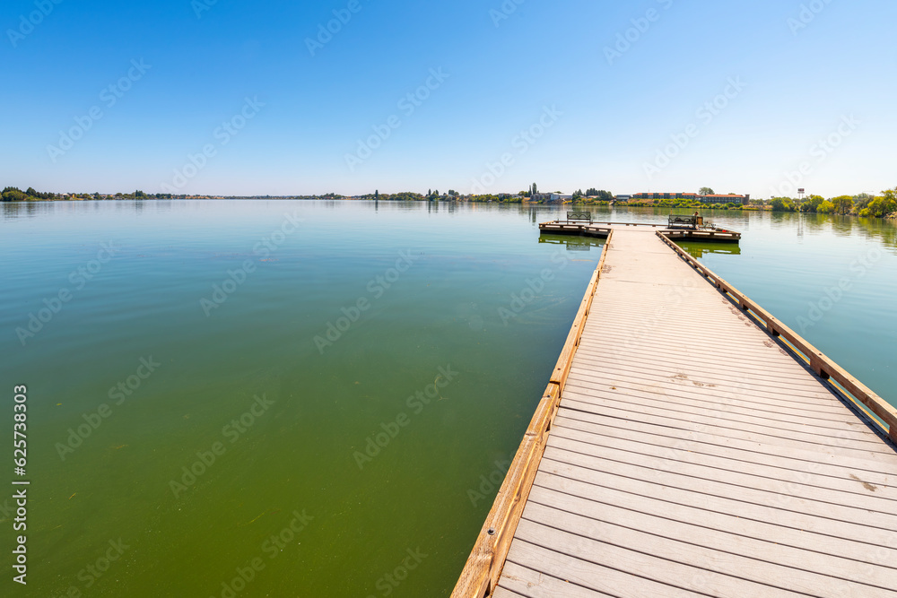 A man fishes off a pier at the 24 acre lakeside Blue Heron Park in the city of Moses Lake, Washington, in Central Washington, USA. A man fishes off a pier at the 24 acre lakeside Blue Heron Park in the city of Moses Lake, Washington, in Central Washington, USA.