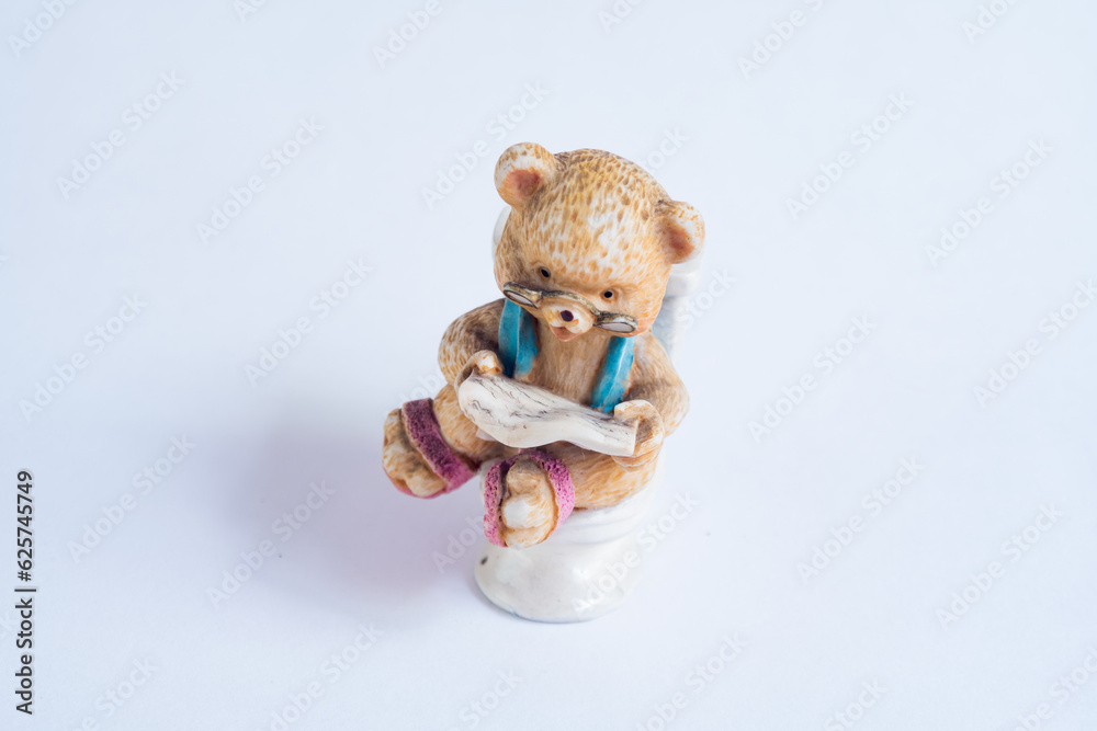 Quiet moment reading the news in the bathroom, bear with glasses sits on the toilet Quiet moment reading the news in the bathroom, bear with glasses sits on the toilet
