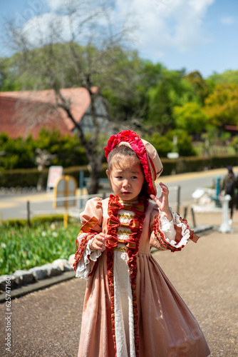 A girl wearing a traditional costume and holding a hat