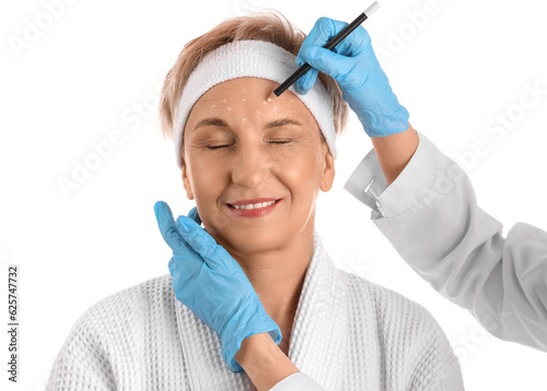 Beautician marking forehead of mature woman for filler injection on white background  closeup