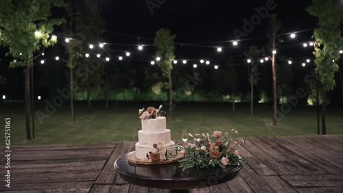 wedding cake on outdoor table at night with lights photo