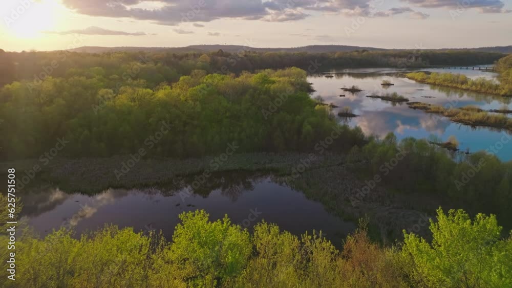 Dolly back reveals sunset over forest treetops at Lake Sequoyah, White River, near Fayetteville Arkansas - Aerial Dolly back reveals sunset over forest treetops at Lake Sequoyah, White River, near Fayetteville Arkansas - Aerial