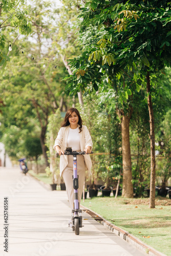 Wallpaper Mural asian woman riding electric scooter in the park, lifestyle concept Torontodigital.ca