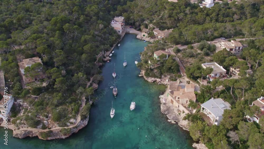 Tilt up shot of famous Port de Cala Figuera with yachts in water, aerial