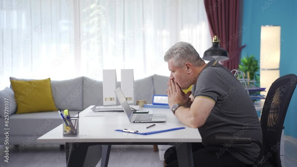 Home office worker man reading bad news and feeling frustrated. Home office worker man reading bad news and feeling frustrated.