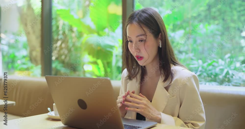 Asian business woman have online meeting with team. She using computer to work in co-working space. Asian business woman have online meeting with team. She using computer to work in co-working space.