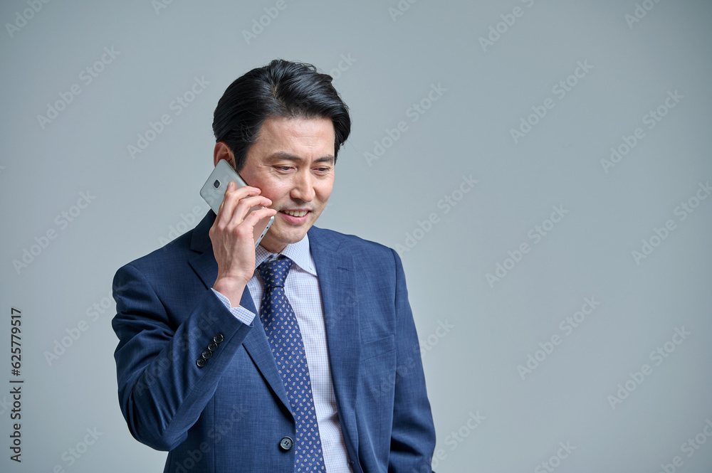 A middle-aged office worker in a suit is holding a smartphone and making various emotional expressions. A middle-aged office worker in a suit is holding a smartphone and making various emotional expressions.
