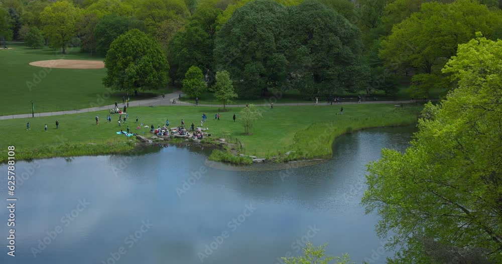 High angle view of people relaxing on pond shores of Central Park in New York, United States of America High angle view of people relaxing on pond shores of Central Park in New York, United States of America