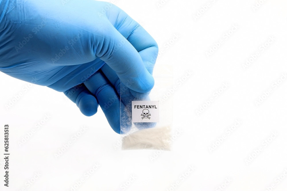 Blue glove holding a pouch of fentanyl, a potent opioid that causes overdose deaths - obrazy, fototapety, plakaty 