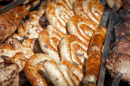 Sausage on steel skewers, selected focus. Grilled sausage. Street food. Meat on steel skewers