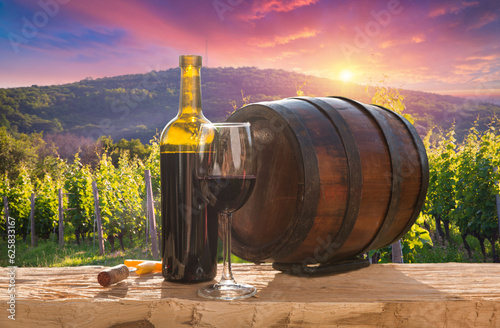 Three glasses with white, rose and red wine on a wooden barrel in the vineyard. Wide photo. High quality photo