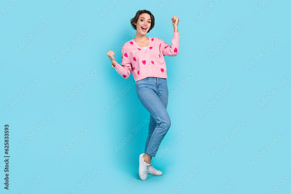 Full size photo of delighted cheerful girl raise fists shout yeah hooray isolated on bright blue color background Full size photo of delighted cheerful girl raise fists shout yeah hooray isolated on bright blue color background