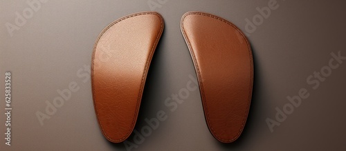 Photo of a pair of brown leather shoes hanging on a wall with ample copy space with copy space