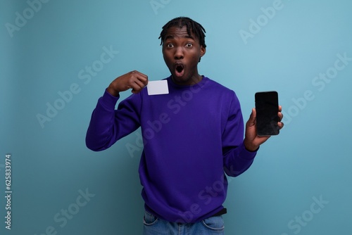 handsome dark-skinned european young man with smartphone for electronic payment