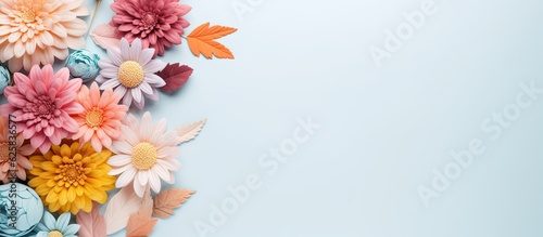 Photo of colorful paper flowers arranged on a vibrant blue background with copy space © HN Works