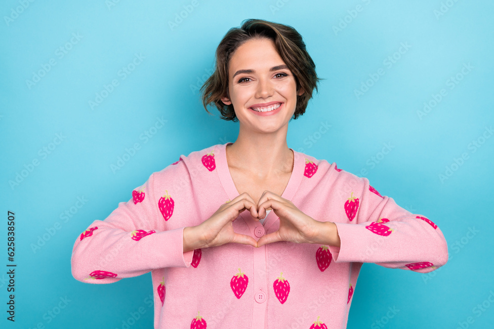 Portrait of cheerful adorable girl wear stylish print clothes make heart symbol demonstrate you sympathy isolated on blue color background Portrait of cheerful adorable girl wear stylish print clothes make heart symbol demonstrate you sympathy isolated on blue color background